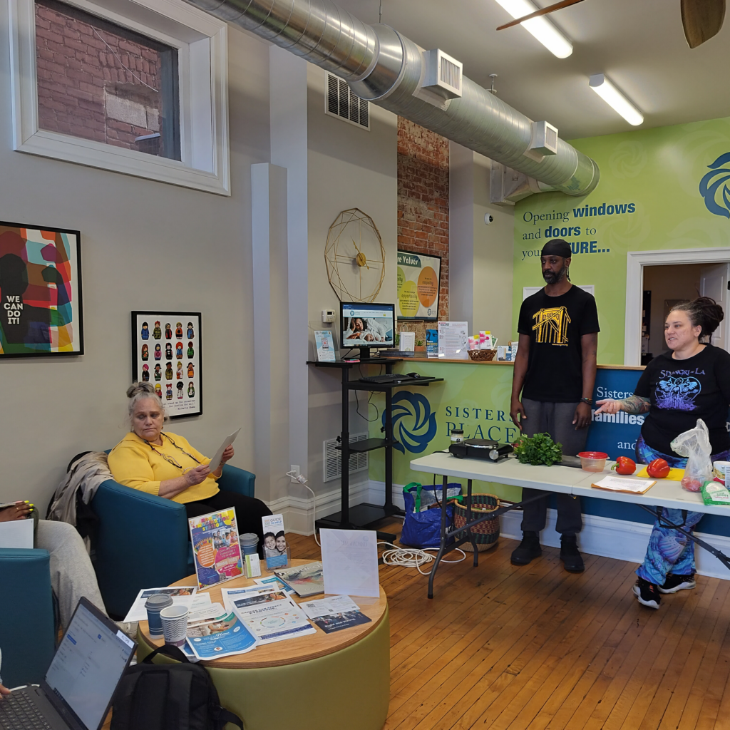  A man and woman giving a health workshop in the Sisters Place lobby space.